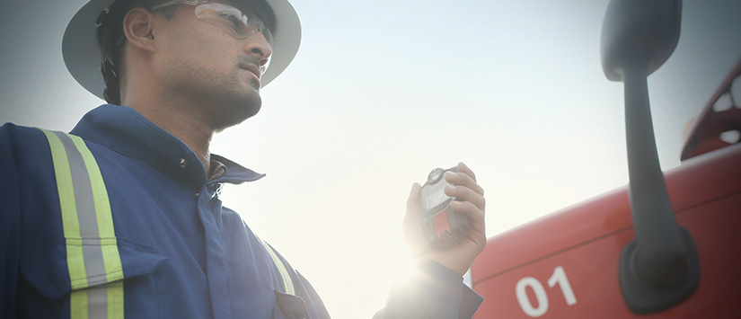 Trabalhador ao lado de um caminhão com o detector de gás Blackline Safety G7 Banner 825x355