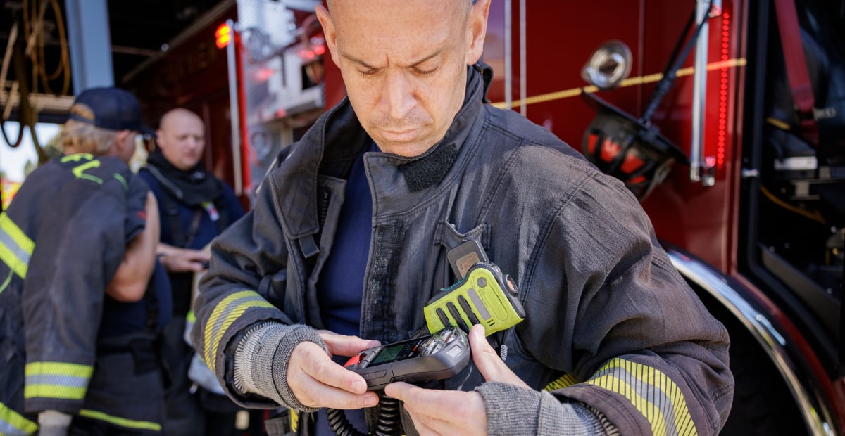 Firefighter attaching his G8 safety wearable to his gear before going out on a call.