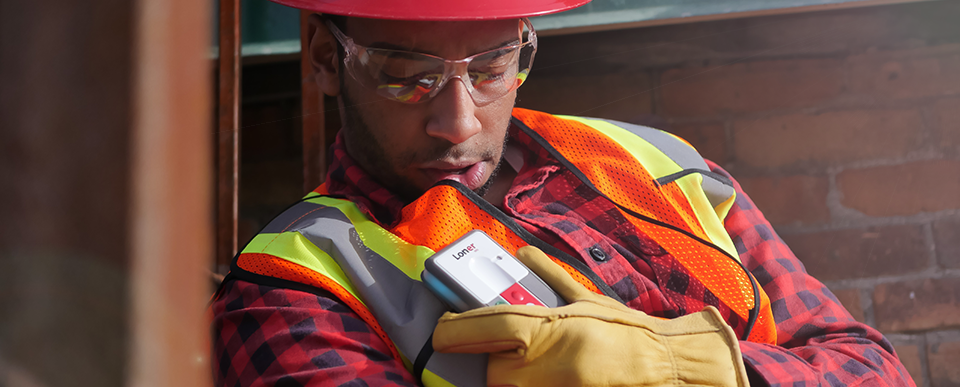 Dispositivo Blackline Safety Loner M6 para trabalhadores isolados sendo usado por um funcionário que precisa de ajuda