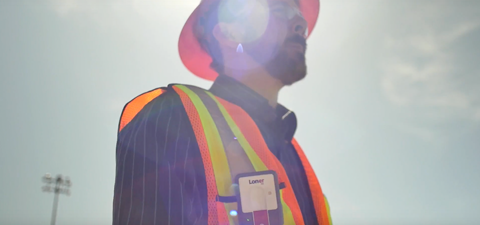 Dispositivo Blackline Safety Loner M6 para trabalhadores isolados, usado por um funcionário que trabalha sob o sol quente.